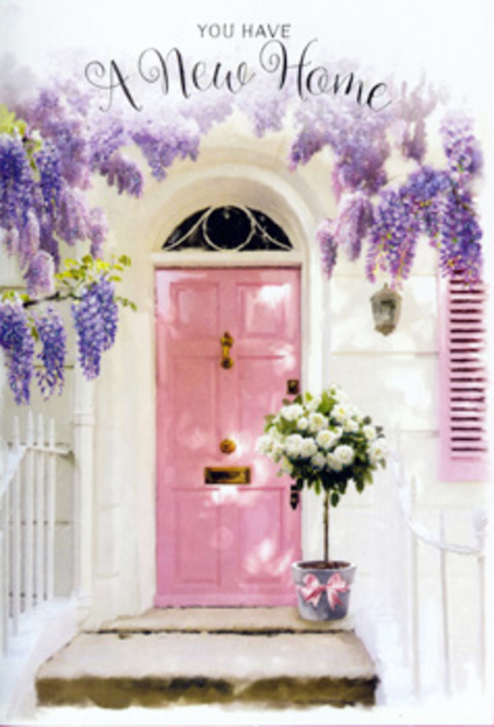 The scene shows a quietly enchanting Brockley doorway that seems to capture the very moment a house becomes a home. Centre stage is a pink front door, painted in a soft, powdery shade that sits beautifully between blush and rose, its colour radiating gentle warmth. The door is set within walls washed in creamy white, whose slightly uneven texture suggests age and character, like many of the period homes around Brockley and St Johns. Above the doorway, a thick veil of wisteria tumbles down, its vines twisting and looping gracefully as they cling to the façade. The blossoms hang in long, tapering clusters of lavender and pale purple, each tiny flower catching glimmers of daylight, as if dusted with a faint shimmer. This floral canopy spills over the top of the door and drifts down the sides, wrapping the entrance in a soft, botanical embrace. On the step, a grey metal bucket anchors the composition, its simple, utilitarian shape contrasting with the romantic abundance of the blooms. From within, an array of creamy white roses rises and spills outward, each bloom at a slightly different stage of opening, from tight buds to fully unfurled petals. Nestled among them, stems of fresh green foliage provide texture and depth, giving the arrangement a just-arrived-from-the-florist freshness. A pale pink satin ribbon encircles the bucket, tied into a graceful bow with ends that trail over the stone, repeating the gentle blush tones of the door. The atmosphere is hushed yet hopeful, a perfect representation of the kind of housewarming design a local Brockley florist might create to mark a first night in a new space, bringing in softness, fragrance, and the quiet promise of many happy days ahead.
